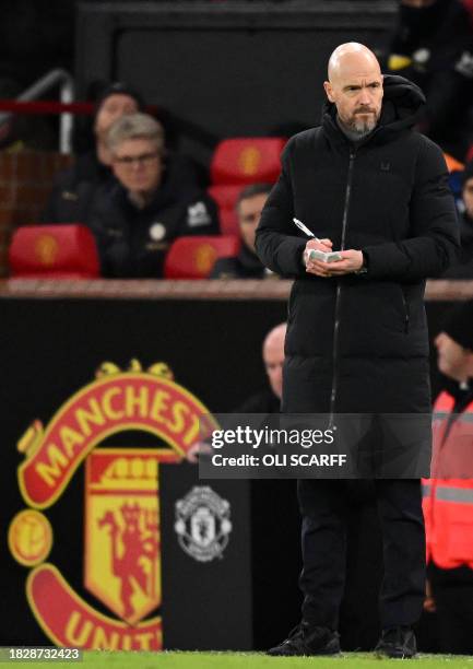 Manchester United's Dutch manager Erik ten Hag makes notes during the English Premier League football match between Manchester United and Chelsea at...