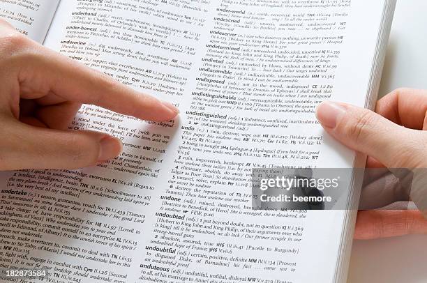 looking up a dictionary - vertaling stockfoto's en -beelden