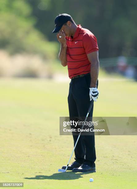 Tiger Woods of The United States wipes his eye before he plays his second shot on the third hole during the final round of the Hero World Challenge...