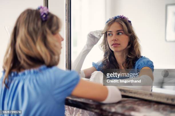 jovem mulher usando um vestido da era regência está se olhando em um espelho. - estilo regency - fotografias e filmes do acervo
