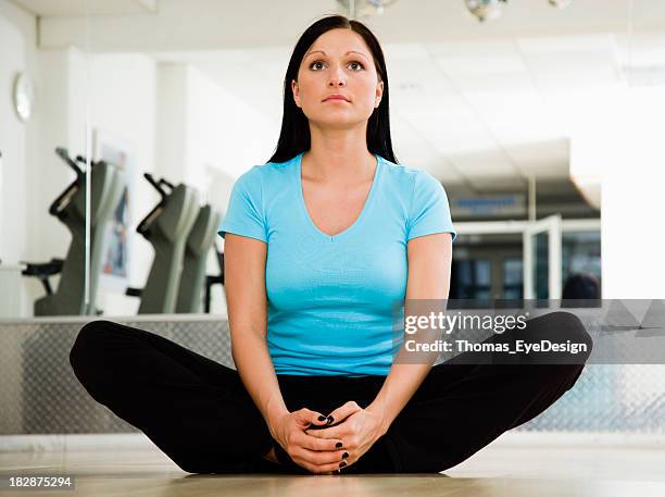 young woman doing a groin stretching exercise - groyne stock pictures, royalty-free photos & images