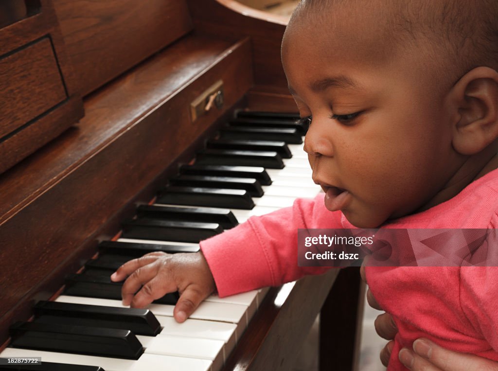 Mother, adopted baby african descent multi-ethnic daughter playing piano