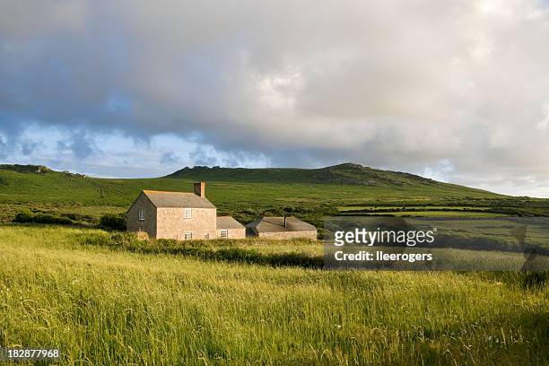 country farm house in a grassy field near moorland - rural house stock pictures, royalty-free photos & images