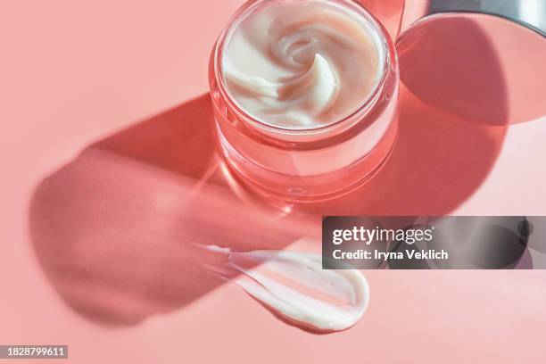 texture of cosmetic product in glass jar - skincare face cream, refreshing hydration water cream or hand cream on natural pastel pink colour background. - retinol stock pictures, royalty-free photos & images
