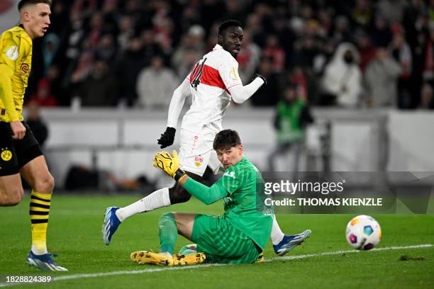 Stuttgart's Congolese forward Silas Katompa Mvumpa scores the 2-0 goal past Dortmund's Swiss goalkeeper Gregor Kobel next to Dortmund's German...