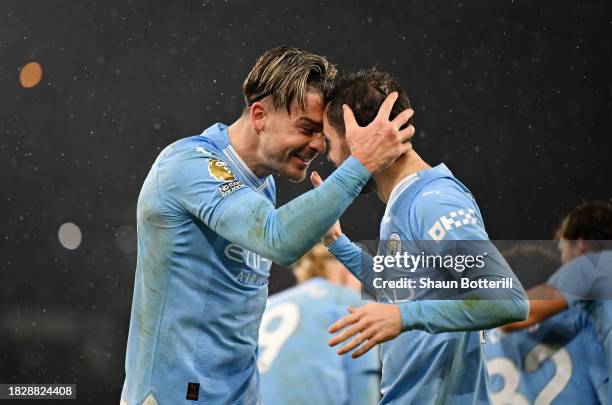 Jack Grealish of Manchester City celebrates with teammate Bernardo Silva after scoring the team's third goal during the Premier League match between...