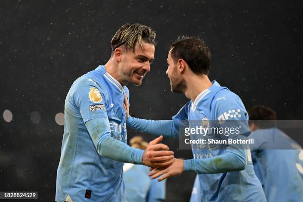 Jack Grealish of Manchester City celebrates with teammate Bernardo Silva after scoring the team's third goal during the Premier League match between...