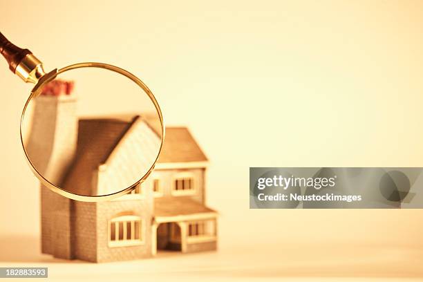 magnifying glass focused on a toy house - glass figurine stock pictures, royalty-free photos & images