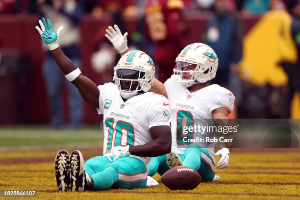 Tyreek Hill of the Miami Dolphins celebrates with teammate Braxton Berrios after scoring a touchdown against the Washington Commanders during the...