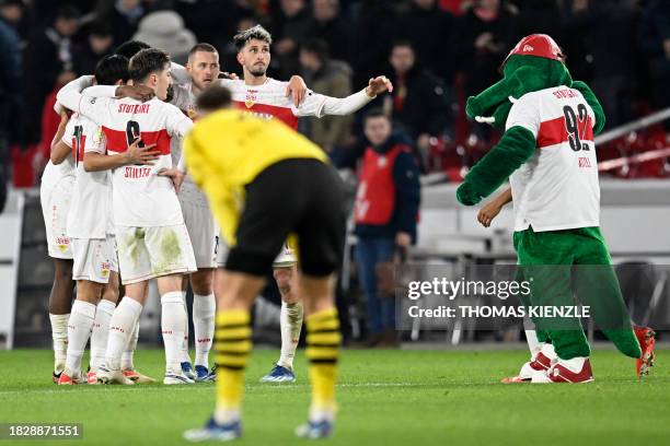 Stuttgart's players celebrate winning with their mascot at the final whitle of the German Cup round of 16 football match between VfB Stuttgart and...