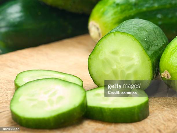 sliced up cucumbers on wooden board - cucumber stockfoto's en -beelden
