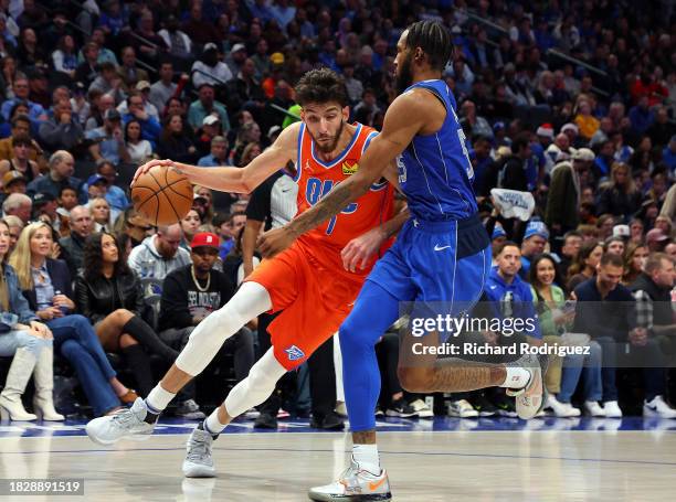 Chet Holmgren of the Oklahoma City Thunder drives the ball against Derrick Jones Jr. #55 of the Dallas Mavericks in the fourth quarter at American...