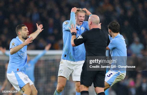 Referee Simon Hooper is surrounded by Erling Haaland, Mateo Kovacic and Ruben Dias of Manchester City after he stopped the game to award Manchester...