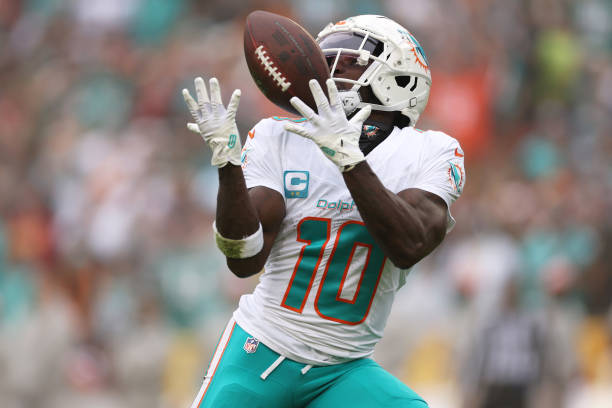 Tyreek Hill of the Miami Dolphins catches a pass for a touchdown against the Washington Commanders during the second quarter of the game at...