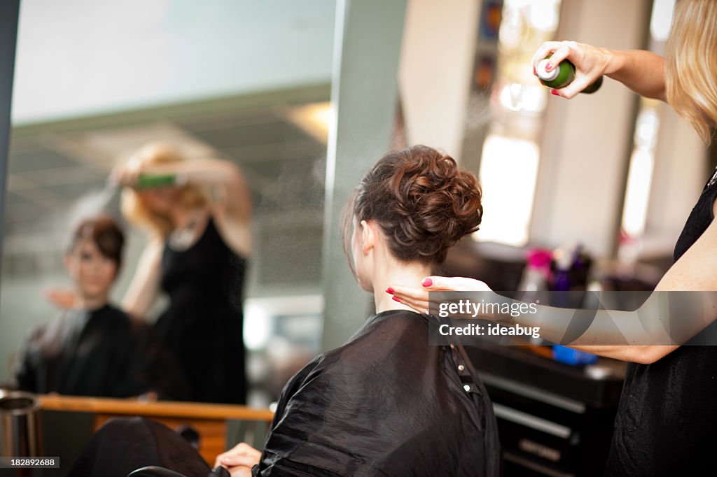 Young Woman Getting Hair Styled as Updo in Salon