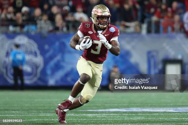 Trey Benson of the Florida State Seminoles runs the ball against the Louisville Cardinals during the ACC Championship at Bank of America Stadium on...
