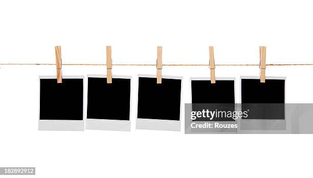 blank instant photo prints on a washing line - wasknijper stockfoto's en -beelden