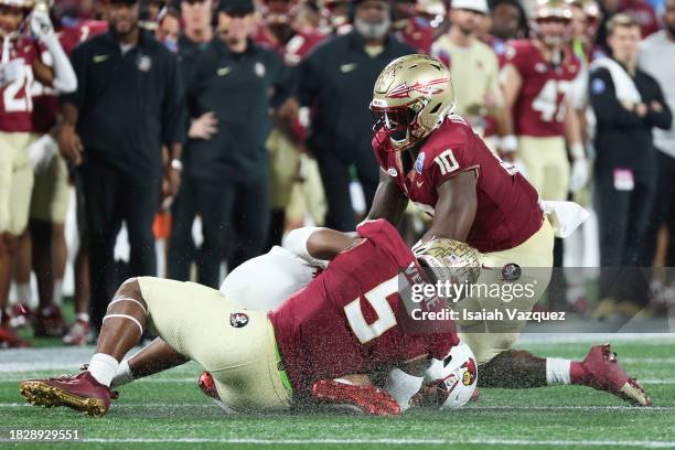 Jared Verse of the Florida State Seminoles makes a sack against the Louisville Cardinals during the ACC Championship at Bank of America Stadium on...