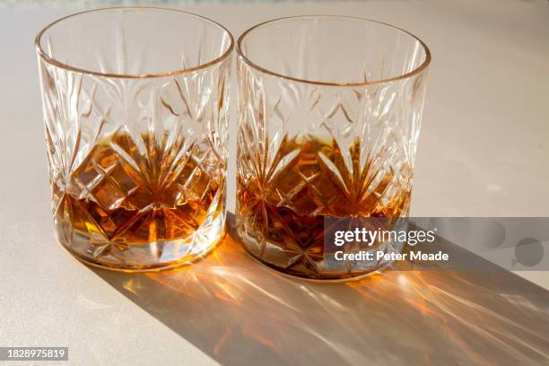 the sun shining on two glasses of whisky - long shadow shadow stock pictures, royalty-free photos & images