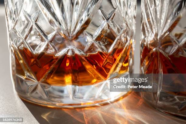 close up of a glass of whisky in the sunshine - spiritueux photos et images de collection