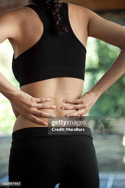 woman with lower back pain - lower back pain stock pictures, royalty-free photos & images