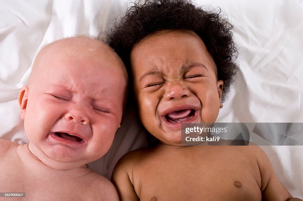 Rostos dos dois multirracial bebês chorando juntos
