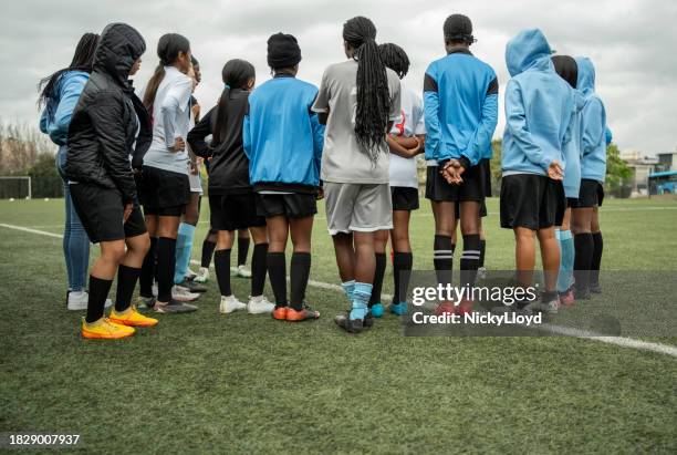 girls soccer team listening to the coach during training session - south africa training session stock pictures, royalty-free photos & images