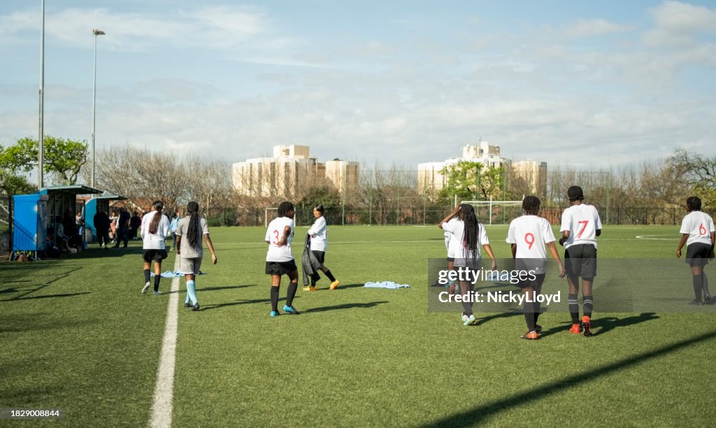 Group of young girl soccer players practicing on sports field