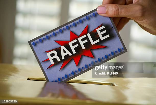 raffle ticket being dropped into a box - raffle tickets stock pictures, royalty-free photos & images