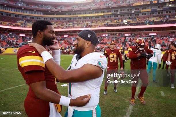 Jacoby Brissett of the Washington Commanders and Tua Tagovailoa of the Miami Dolphins meet on the field after their game at FedExField on December...