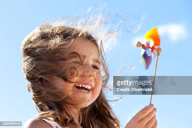 piccolo ragazza felice con tappezzi mulino a vento - vento foto e immagini stock