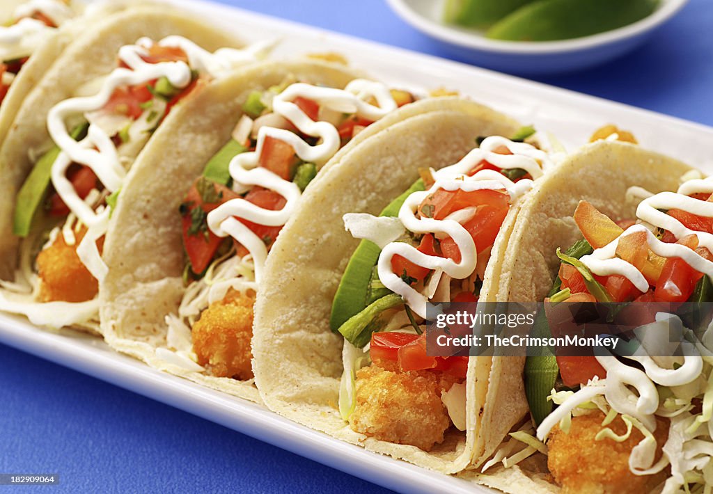 A row of delicious fish tacos on a plate