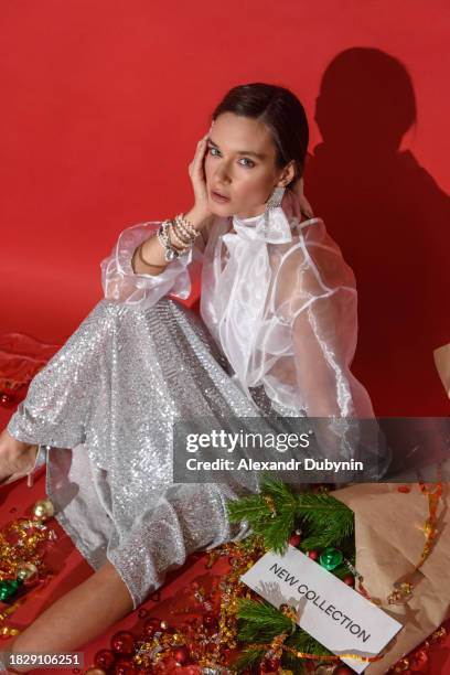 portrait of fashionable woman sitting posing in new collection of christmas clothes. - glamour fotografías e imágenes de stock