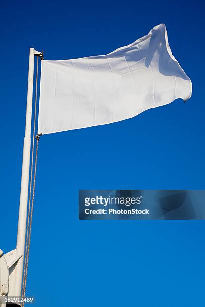 empty white flag waves in front of deep blue sky - white flag stock pictures, royalty-free photos & images