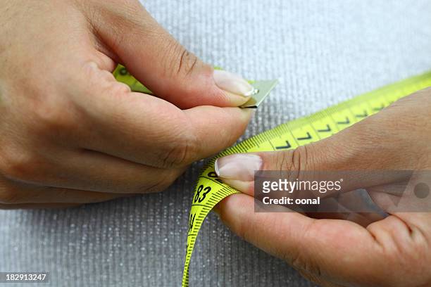 person measuring their waste line - mass unit of measurement stock pictures, royalty-free photos & images