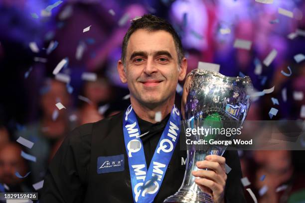 Ronnie O'Sullivan of England celebrates with the MrQ UK Snooker Championship 2023 trophy following victory against Ding Junhui of China in their...
