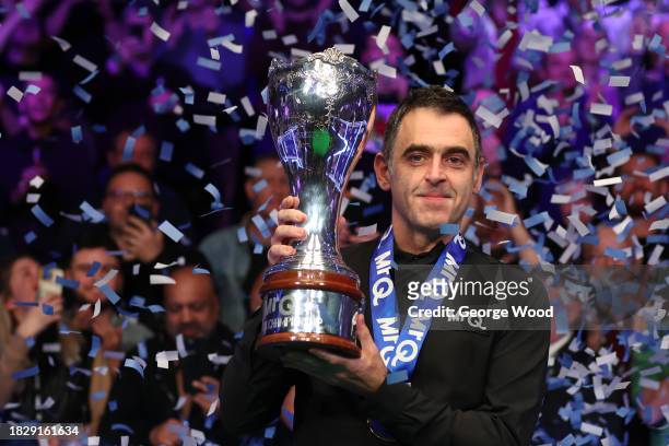 Ronnie O'Sullivan of England celebrates with the MrQ UK Snooker Championship 2023 trophy following victory against Ding Junhui of China in their...