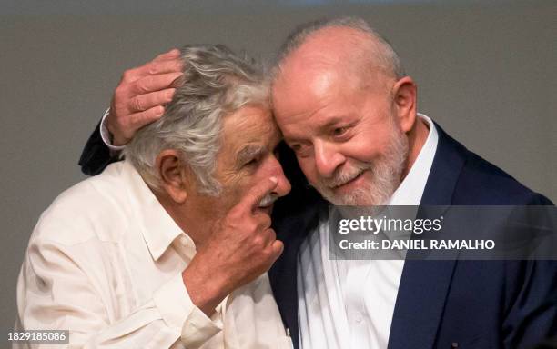 Brazil's President Luis Inacio Lula da Silva and Uruguayan former President Jose Mujica chat during the signing of a loan contract between the...