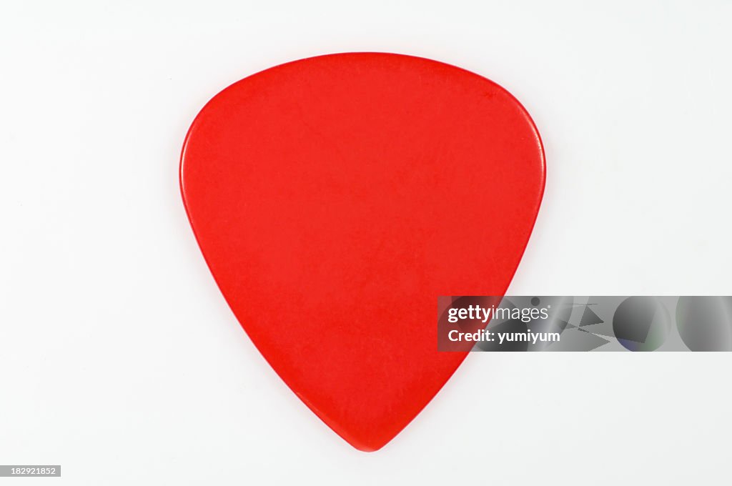 A red guitar pick on a white background