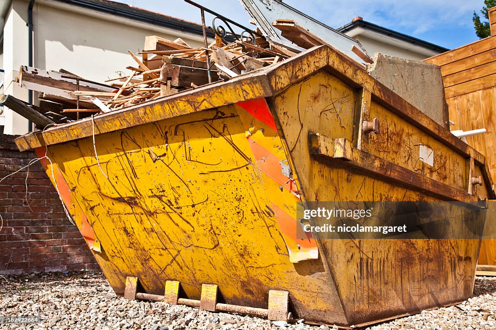 Overflowing industrial bin filled with wooden scraps