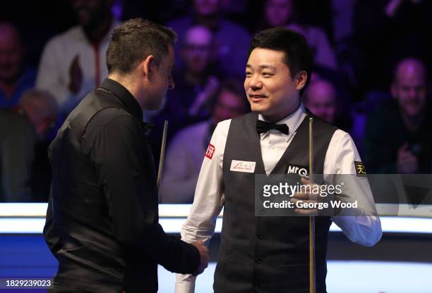 Ronnie O'Sullivan of England and Ding Junhui of China interact following the Final match on Day Nine of the MrQ UK Snooker Championship 2023 at York...