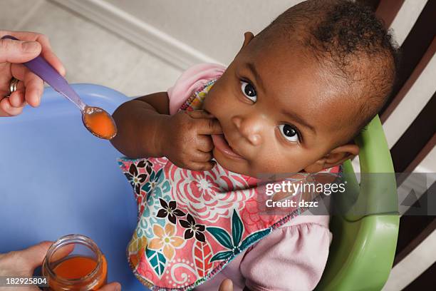 mother feeding adopted baby daughter - baby food jar stock pictures, royalty-free photos & images