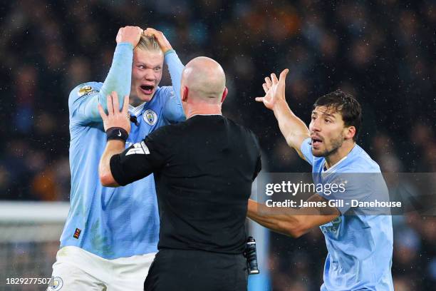 Referee Simon Hooper is surrounded by Erling Haaland, Mateo Kovacic and Ruben Dias of Manchester City after he stopped the game to award Manchester...