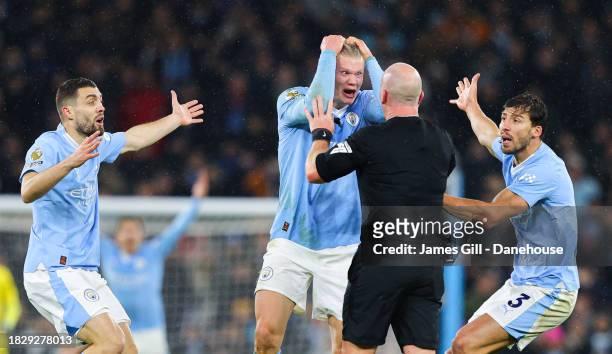 Referee Simon Hooper is surrounded by Erling Haaland, Mateo Kovacic and Ruben Dias of Manchester City after he stopped the game to award Manchester...