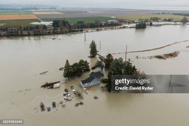 In an aerial view, floodwaters surround a home on December 6, 2023 in Stanwood, Washington. Atmospheric river conditions in the region brought heavy...