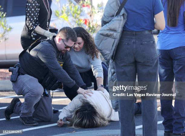 Police attend to a person near Maryland Parkway following a shooting on the UNLV campus in Las Vegas Wednesday, Dec. 6, 2023.