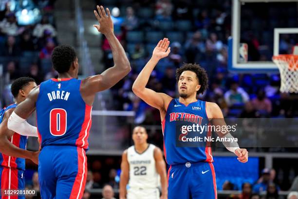 Jalen Duren of the Detroit Pistons and Cade Cunningham of the Detroit Pistons high five against the Memphis Grizzlies during the second quarter at...