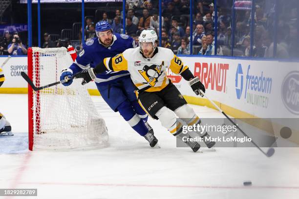 Nicholas Paul of the Tampa Bay Lightning against Kris Letang of the Pittsburgh Penguins during the second period at Amalie Arena on December 6, 2023...