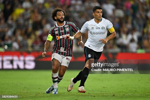 Fluminense's defender Marcelo and Gremio's forward Uruguayan Luis Suarez fight for the ball during the Brazilian Championship football match between...