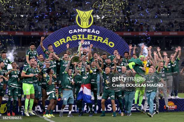 Palmeiras' players celebrate with the trophy after winning the Brazilian Championship following the football match between Cruzeiro and Palmeiras at...